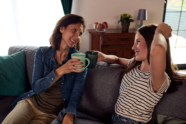 istock Two women enjoy coffee on a sofa, sharing a warm, friendly moment at home 2238487808