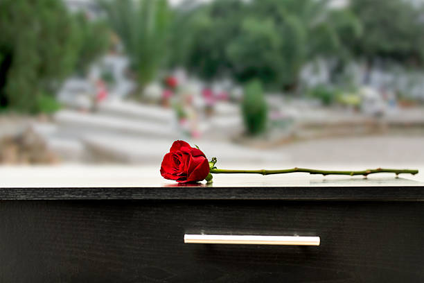 istock One red rose over a coffin at a cemetery 2238492959