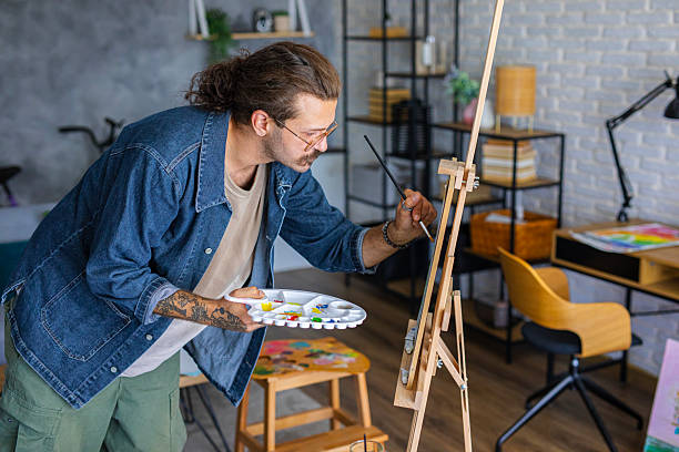 istock Painter enjoying the creative process of painting on canvas at home studio workspace 2238493132