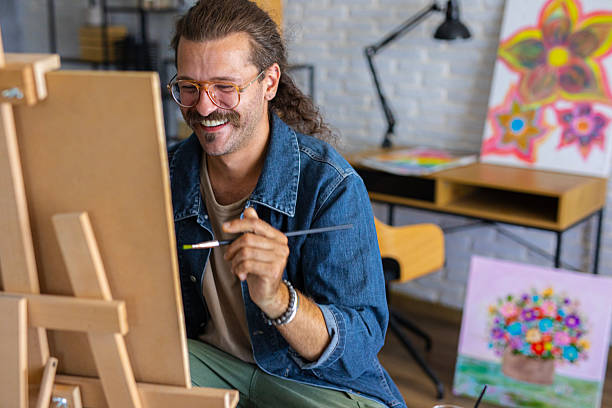 istock Painter enjoying the creative process of painting on canvas at home studio workspace 2238493307