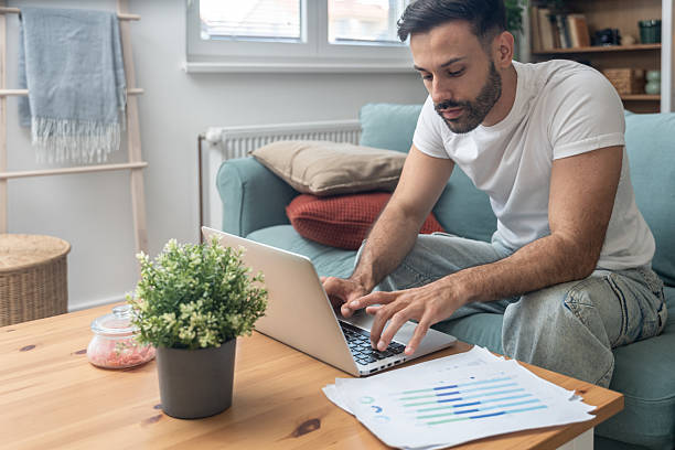 istock Young university student, freelancer business man, working at home on laptop computer, testing new innovative technology and online internet tools while sitting in home office. 2238493780