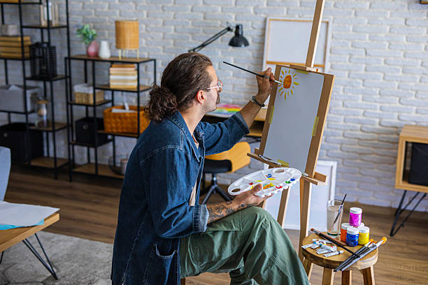 istock Painter enjoying the creative process of painting on canvas at home studio workspace 2238495273