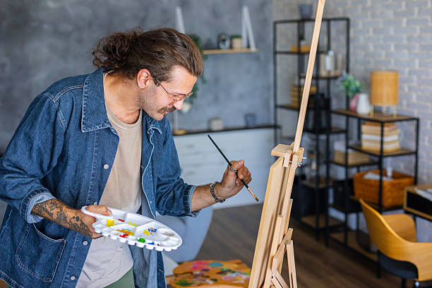 istock Painter enjoying the creative process of painting on canvas at home studio workspace 2238495552