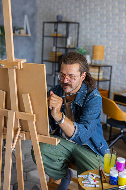 istock Painter enjoying the creative process of painting on canvas at home studio workspace 2238495630