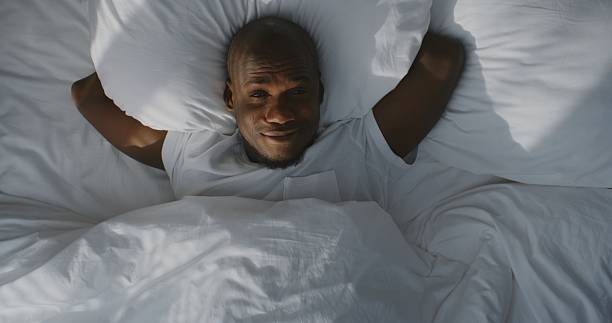 istock Peaceful Guy Waking Up Cozily in Bed, Bathed in Warm Sunlight 2238499236