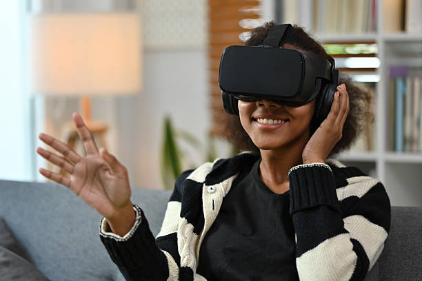 istock A smiling young African woman wearing a VR headset explores virtual content while relaxing in a cozy living room 2238499917
