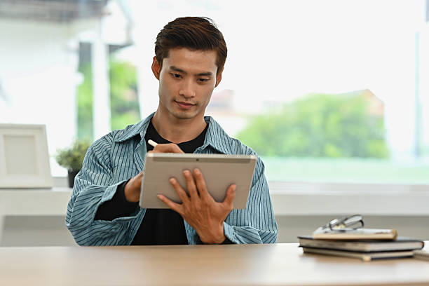 istock A Focused Designer Working on Digital Art with Stylus, Digital Artist Creating on Tablet 2238500158