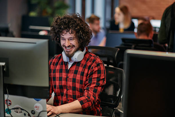 istock Focused Programmer With Afro Hairstyle in Plaid Shirt Working on Computer in Office Environment 2238502060