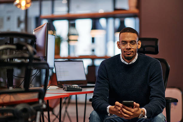 istock After Hours Reflection: African American Man Using Smartphone in Office. 2238502577