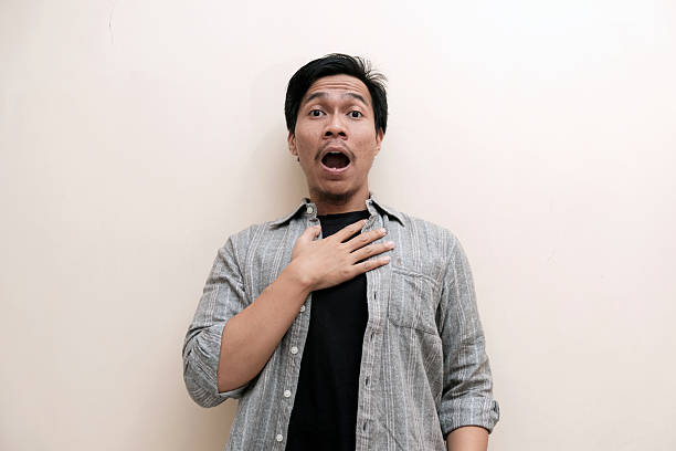 istock Southeast Asian man wearing flannel shirt showing shocked face expression 2238508926