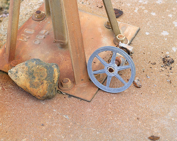 A rusty water meter sitting on a concrete floor.