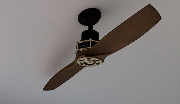 istock Suspended Wooden Ceiling Fan Under Exposed Ceiling. 2238510260