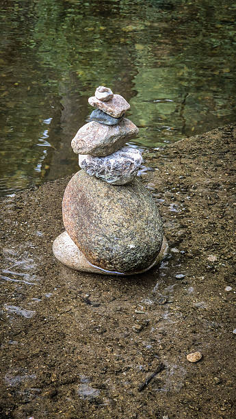 istock Stacks of balanced river pebbles on the water’s edge symbolize harmony, peace, and focus. Reflective surface and smooth stones evoke zen, mindfulness, and natural art. 2238512090