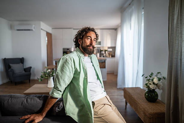 istock Man relaxing on couch thinking at home 2238513079