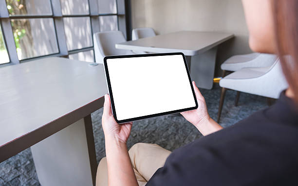 Mockup image of a woman holding digital tablet with blank white desktop screen