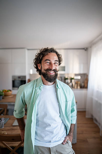 istock Smiling man standing in modern kitchen at home 2238513128