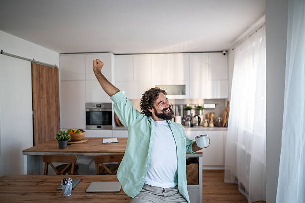 istock Happy man stretching with coffee in modern kitchen 2238513214