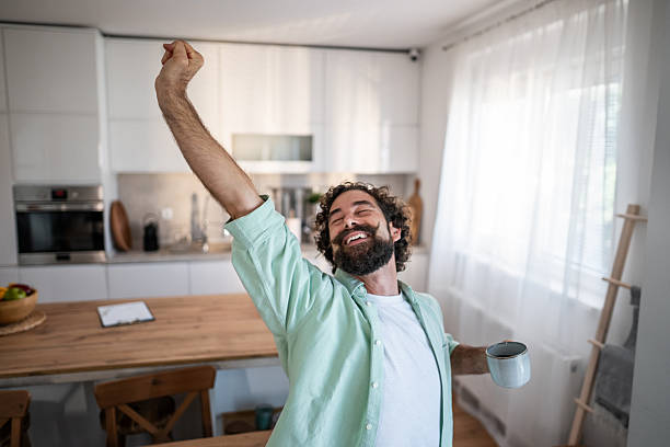 istock Happy man stretching in kitchen enjoying morning coffee 2238513244