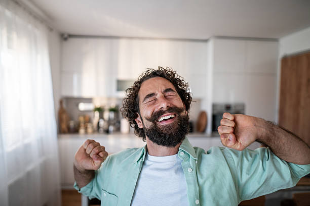 istock Happy man stretching, waking up with joy at home 2238513249