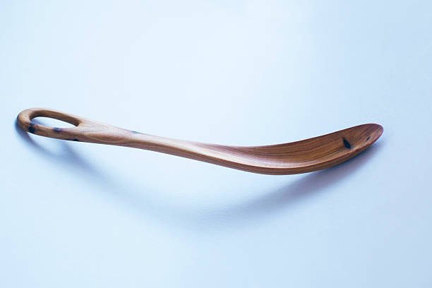 Close-up shot of hands skillfully carving a wooden spoon. This image captures the essence of woodworking, craftsmanship, and the creation of unique handmade utensils. Ideal for illustrating traditional skills, hobbies, or artisan products.