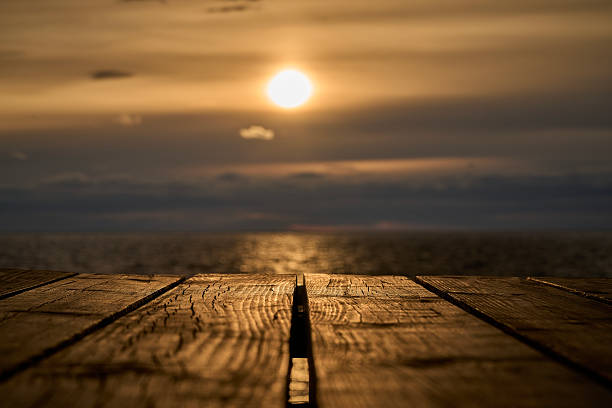 Sunset at Pomorie town shot from the pier. Calm sea water against cloudy sky. Bulgaria, Eastern Europe.