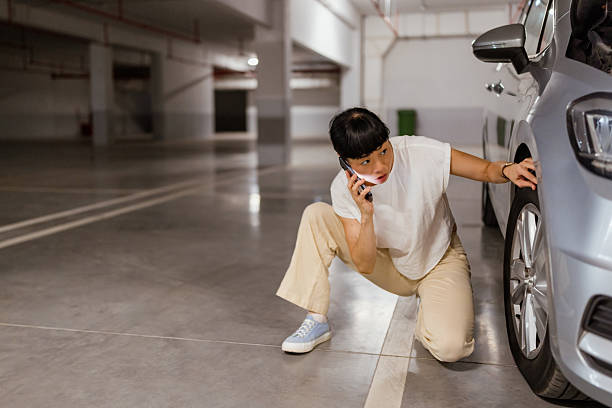 istock Japanese woman calling for help on cell phone about a tire problem 2238519765