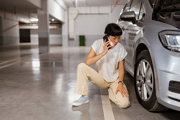 istock Japanese woman calling for help on cell phone about a tire problem 2238519766
