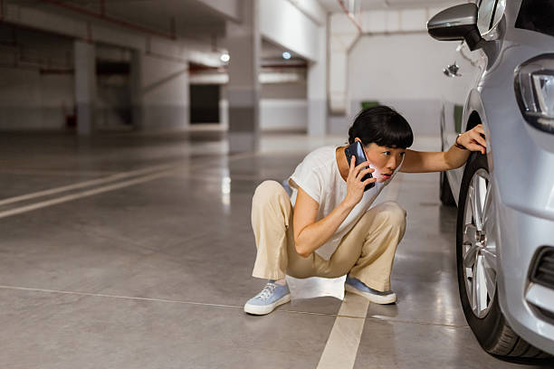 istock Japanese woman calling for help on cell phone about a tire problem 2238520720
