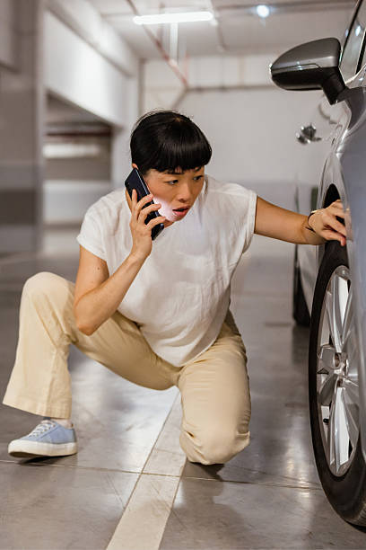 istock Japanese woman calling for help on cell phone about a tire problem 2238520890