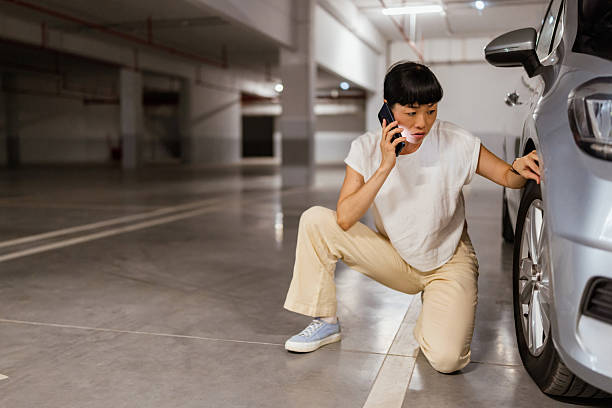 istock Japanese woman calling for help on cell phone about a tire problem 2238521076