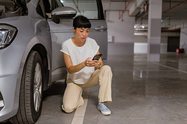 istock Japanese woman calling for help on cell phone about a tire problem 2238521212