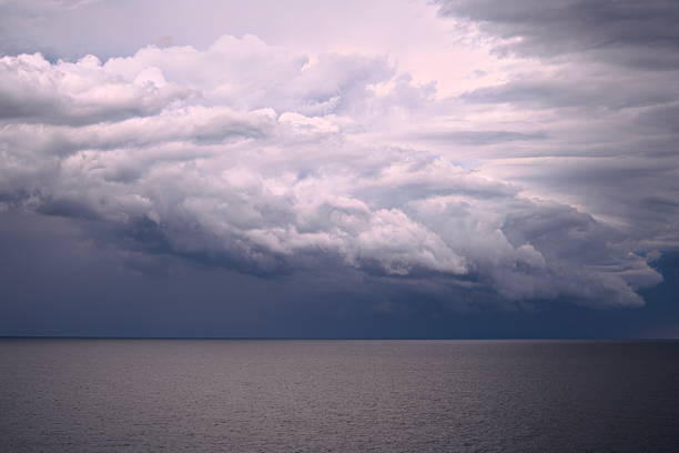 The mesmerizing view of storm clouds flowing over a tranquil ocean during enchanting twilight hours