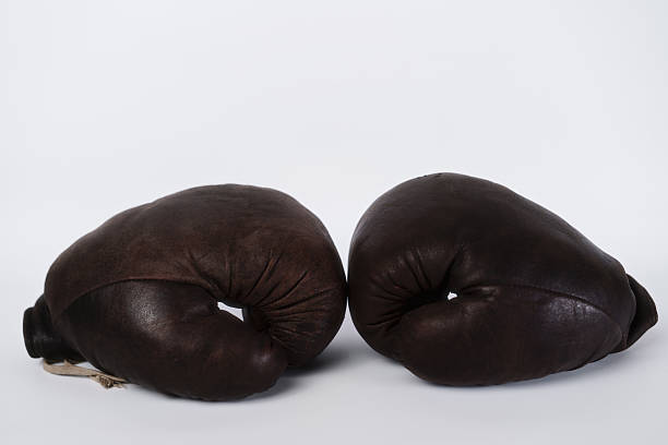 istock Vintage leather boxing gloves displayed side by side on a plain background 2238523633