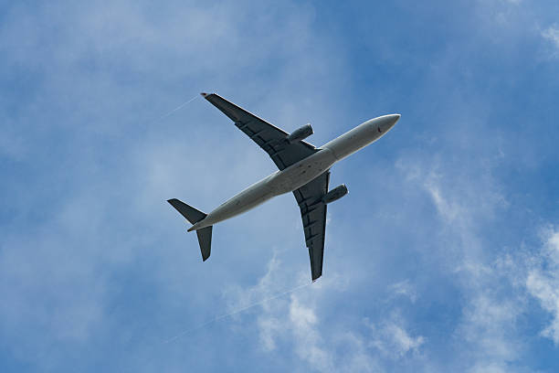 istock Commercial airplane with contrails from the wingtips flying in a clear blue sky. 2238525910