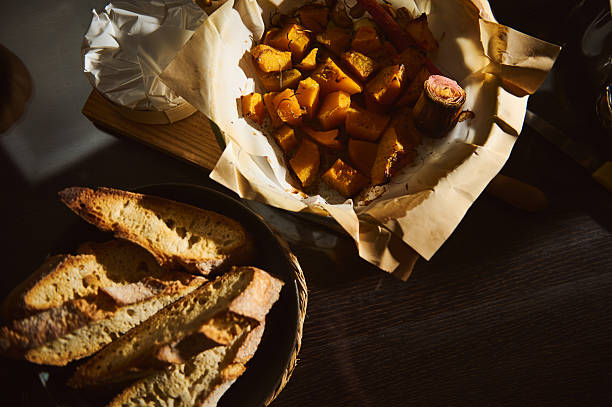 Crusty Bread Slices And Golden Roasted Potatoes On Paper Wrapping For A Rustic Home Meal
