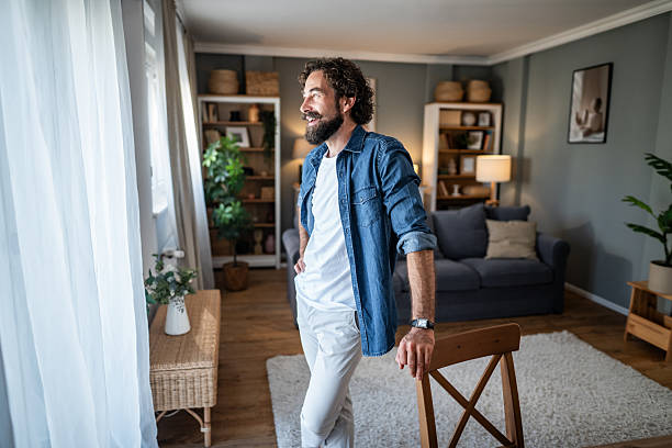 istock Relaxed man smiling, looking out window at home 2238528715