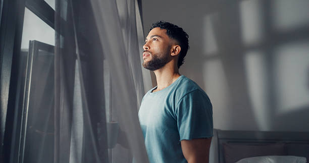 istock Thinking, curtain and window with man in bedroom with coffee for wake up, reflection and memory. Vision, perspective and future with male person and tea in home for inspiration, morning and idea 2238529378