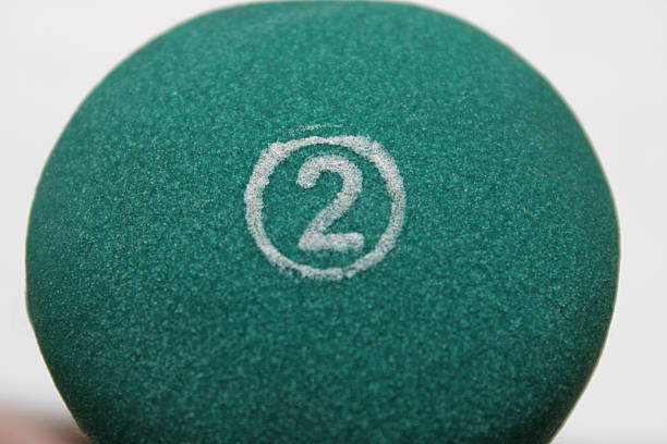 A closeup of the number 2 on a green ball.