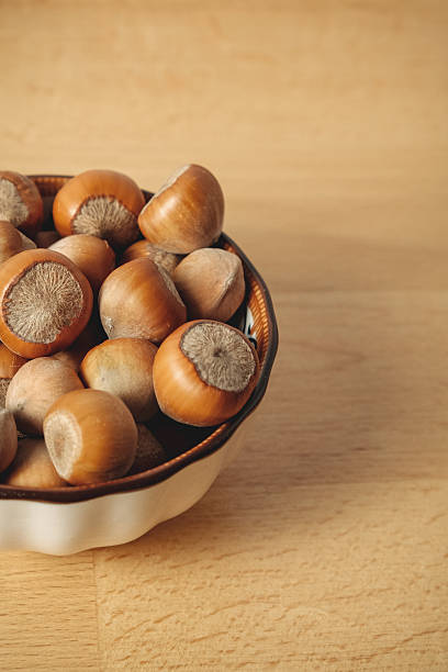 istock Freshly harvested hazelnuts in a rustic bowl on a wooden table 2238532030