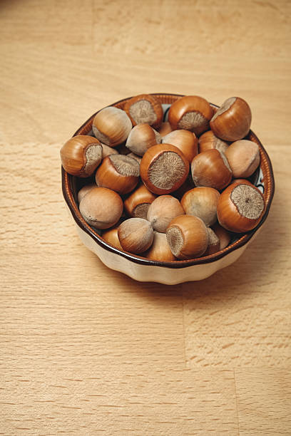 istock Nuts piled high in a charming bowl on a wooden table for a cozy snack 2238532050