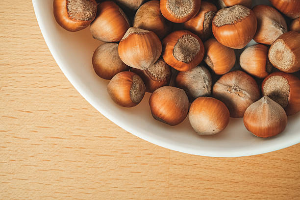 istock Hazelnuts arranged beautifully in a white bowl on a wooden table 2238532256