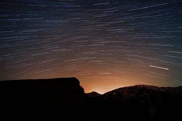 istock Star trails over a mountain silhouette 2238532697