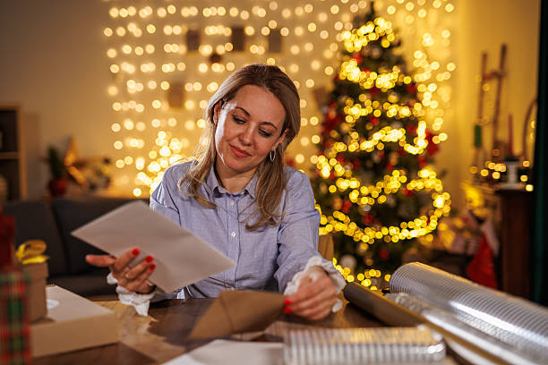 istock Woman at desk reviewing documents by a Christmas tree in a festive home setting 2238532724