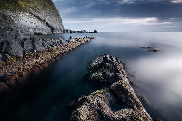 Rocky coastline and calm sea at dusk