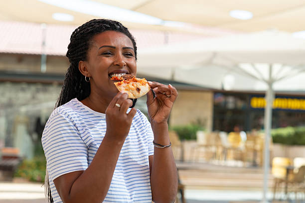 istock Woman Smiling While Eating Pizza Outdoors. 2238541508