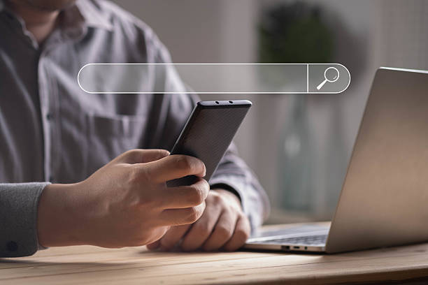 istock Businessman using smartphone with virtual search bar interface, concept of online search, SEO, digital marketing, internet research, web browsing, modern technology, and information access. 2238543009