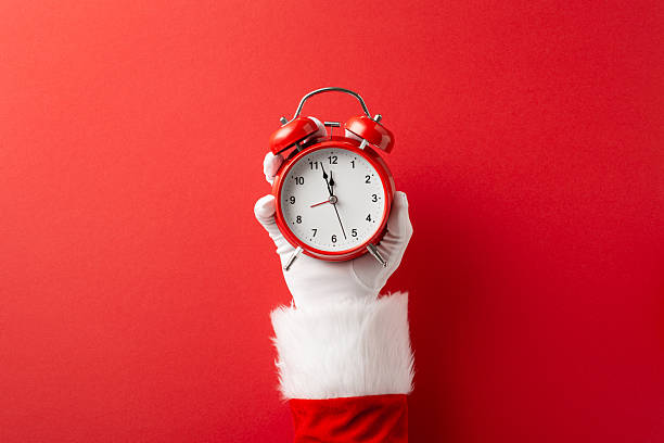 istock A bright red alarm clock held by a white gloved hand against a bold red backdrop evokes festive season, holiday cheer, and time for Christmas and New Year celebrations 2238543629