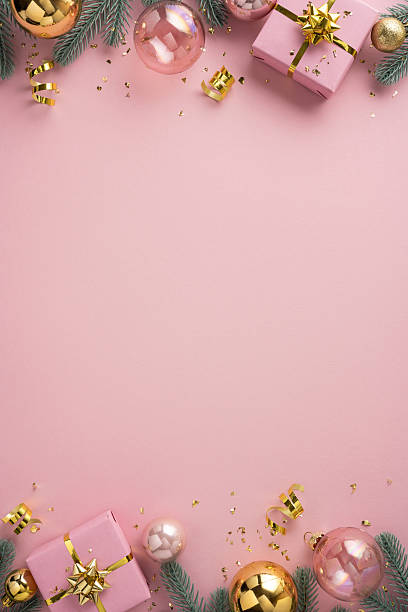 istock Pink vertical holiday backdrop with wrapped gift boxes, glass baubles, pine needles and gold ribbons evokes Christmas and New Year celebration and warm festive mood 2238543649