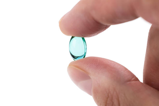 istock Man's hand holding blue gel capsule isolated on white background. Close up. High resolution product 2238545496