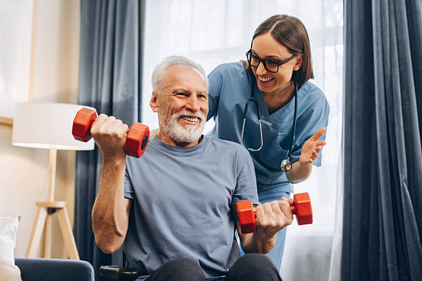 istock Senior man smiling, lifting weights with home caregiver 2238545704
